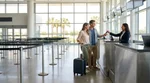 Passengers waiting in line at a car hire counter inside the Orlando airport terminal