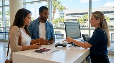 Person receiving keys across a car rental desk in a sunny Florida terminal