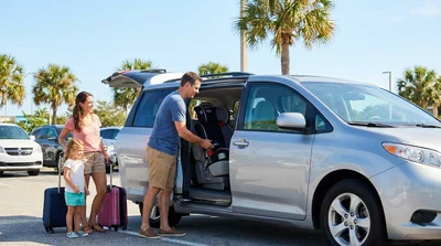 Child booster seat secured in the back seat of a car rental in sunny Florida