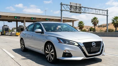 White car rental driving through a FasTrak toll lane on a California highway