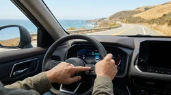 Driver holding the steering wheel of a modern car rental on a sunny highway in California