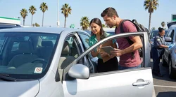 Person signing a car hire agreement on the hood of a spotless vehicle in Los Angeles