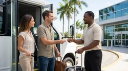 Driver loading luggage onto a car rental shuttle bus outside a sunny Florida airport