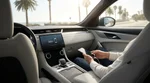 Driver using a smartphone connected to an Apple CarPlay dashboard screen in a California car rental