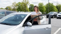Person reviewing car rental paperwork on the hood of a vehicle in Pennsylvania