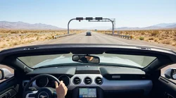 A silver car rental driving on a desert highway with the Las Vegas skyline ahead