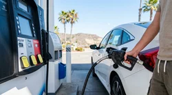 Close up of a gas pump nozzle filling a car rental at a California gas station