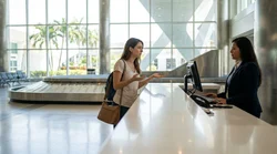 Traveler with hand luggage standing at a car rental counter in Miami airport