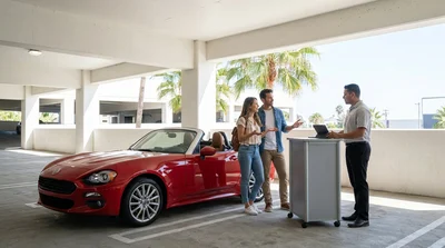 Traveler standing with luggage outside a car rental office in Los Angeles