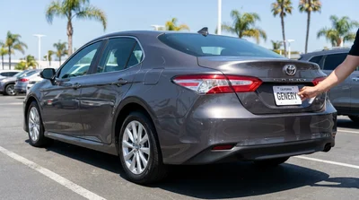 Rear bumper of a car rental in California displaying a temporary paper license plate