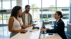 Customer handing a physical credit card to an agent at an Orlando car rental desk