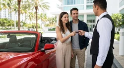 White automatic car rental driving along a sunny coastal road lined with palm trees in Miami