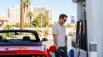 A person pumping gas into a car rental at a Las Vegas gas station