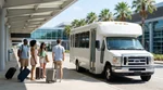 A white car rental shuttle bus picking up passengers outside the terminal at Miami Airport