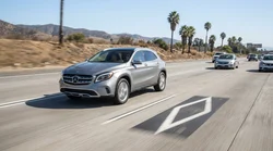 White car rental driving in an HOV lane marked with a diamond symbol on a sunny California freeway