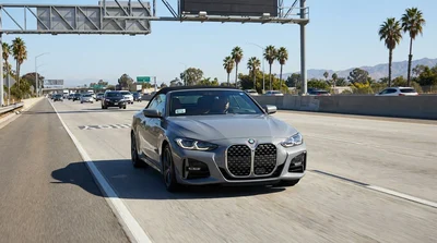 Silver car rental traveling in the HOV express lane on a sunny California highway