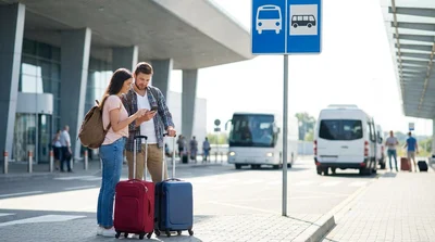 A car rental shuttle bus picking up passengers with luggage outside an airport terminal in New York