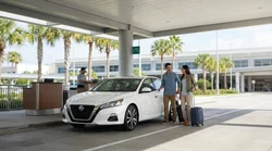 Two adults signing paperwork at a car hire desk in Orlando