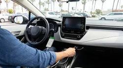 Driver connecting a smartphone to a dashboard with a USB cable in a Los Angeles car rental