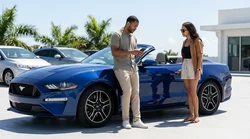 Traveler inspecting a white car rental in a sunny Miami parking lot with palm trees