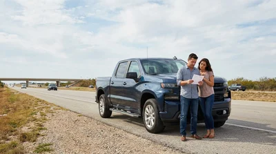 White car rental driving along a straight paved highway through a sunny desert landscape in Texas