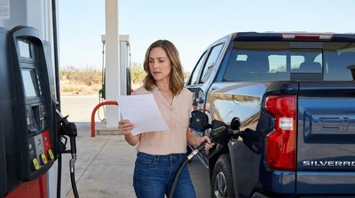 Close up of a fuel nozzle filling a car rental vehicle at a Texas gas station