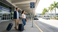 Travelers with luggage waiting for a car rental shuttle bus outside the LAX international terminal in Los Angeles
