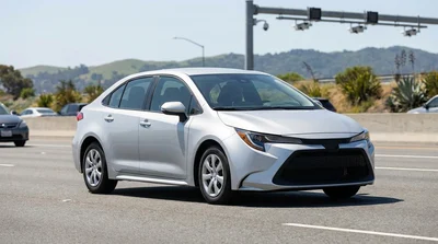 White car rental driving in a highway toll lane with the San Francisco skyline in the background
