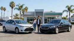 Standard sedan and full-size SUV parked side by side in a sunny Los Angeles car rental lot near palm trees