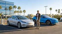White electric car rental plugged into a charging station on a sunny street in California