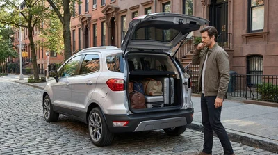 Traveler loading luggage into the trunk of a car hire on a New York street