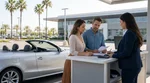 Customer receiving keys at a sunny California car rental counter