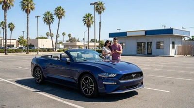 A traveler checking their watch next to a vehicle at a car rental lot in California