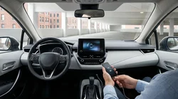 Smartphone displaying Android Auto plugged into a car rental dashboard on a New York street