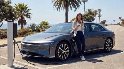 White electric car rental driving along a scenic coastal highway in California