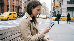 Driver navigating with a smartphone map app inside a car rental on a New York street