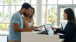 Person handing a credit card to a staff member at an Orlando car rental desk
