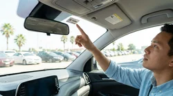 White electronic toll tag mounted to the upper windshield of a Texas car rental