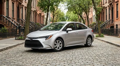 Hands on the steering wheel of a car rental driving through downtown New York