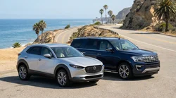 Modern SUV car rental driving along a sunny coastal highway in California