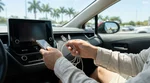 Driver plugging a phone charging cable into the USB port of a Florida car rental