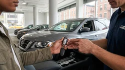 Person holding a key fob next to a car rental vehicle on a New York street