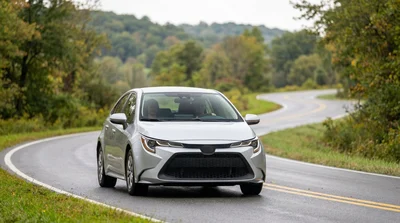 A white car rental driving on an open highway surrounded by green trees in Pennsylvania