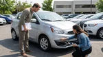 Person with a clipboard inspecting the bumper of a car rental in a Pennsylvania parking lot