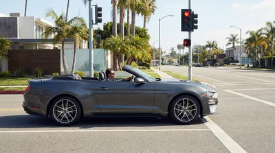 Person driving a car rental making a right turn at a red traffic light in California