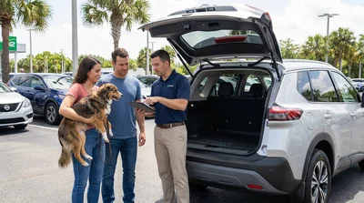 Dog looking out the open window of a car rental parked near palm trees in Florida