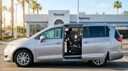 Parent buckling a toddler into a car seat inside a car hire in sunny California