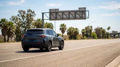 White car rental driving on a sunny highway toward a Florida state border sign