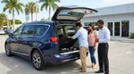 Open trunk of a car rental parked near Florida palm trees revealing a spare tire inside