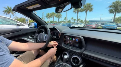 Person plugging a smartphone cable into the dashboard USB port of a Florida car rental